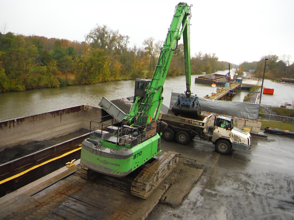 Two SENNEBOGEN 870 material handlers unload 6 to 8 barges of dredged sediment from the Hudson River every day.
