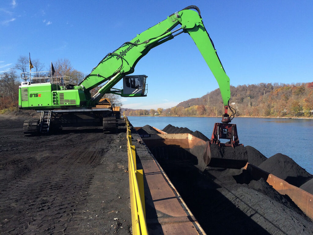 The 875’s glass-floored cab elevates and extends outward to give operators a clear view into barge holds, allowing them to offload a full barge in less than 90 minutes.