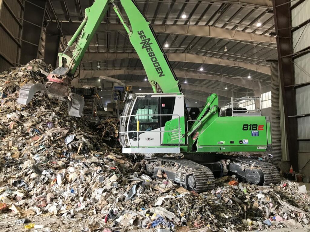 Moving in for a closer look, the reach on the machine allows them to efficiently sort and work the pile.